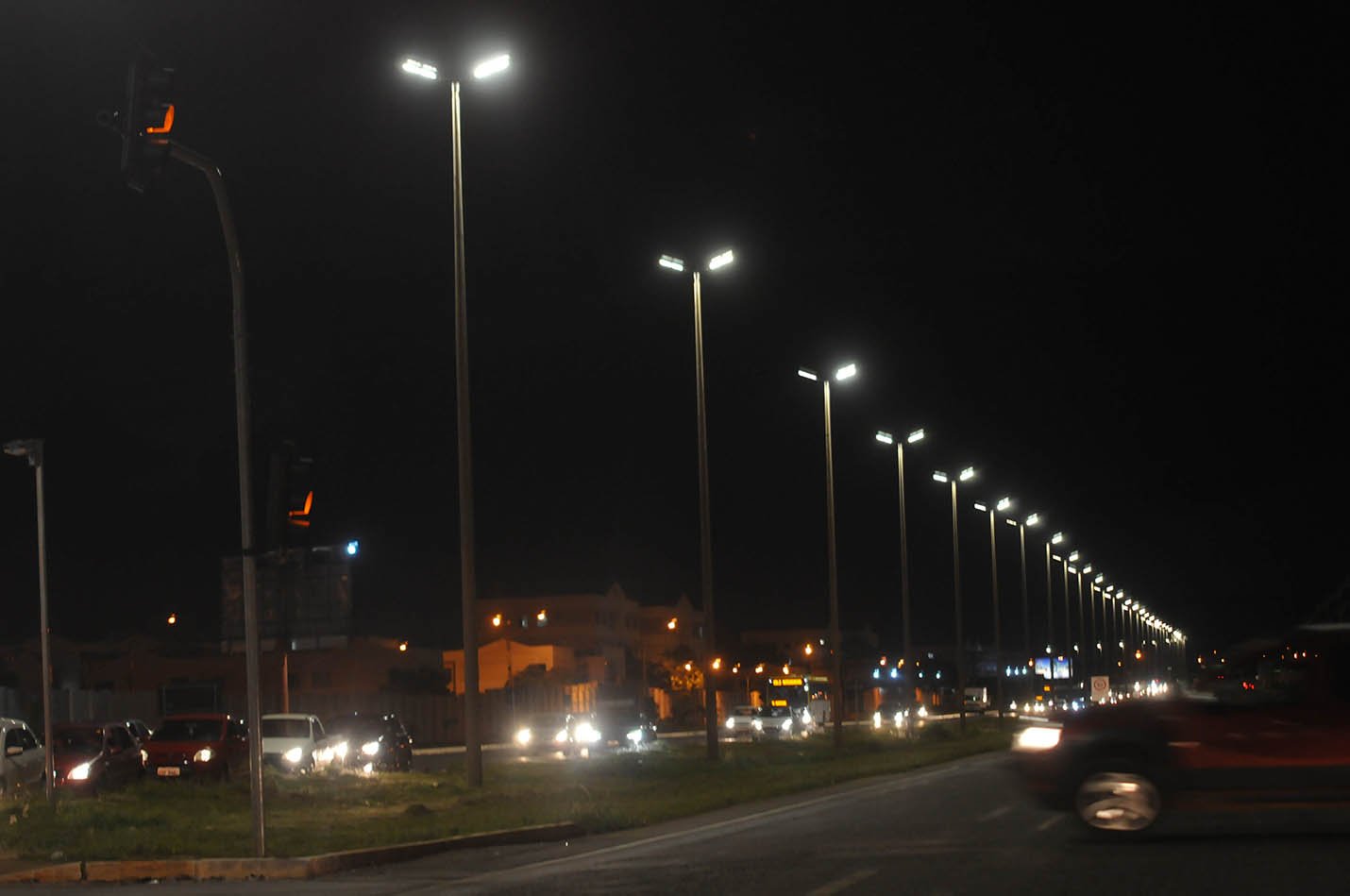 Avenida do Distrito Federal à noite com fileira de postes de iluminação LED acesos, foto de arquivo