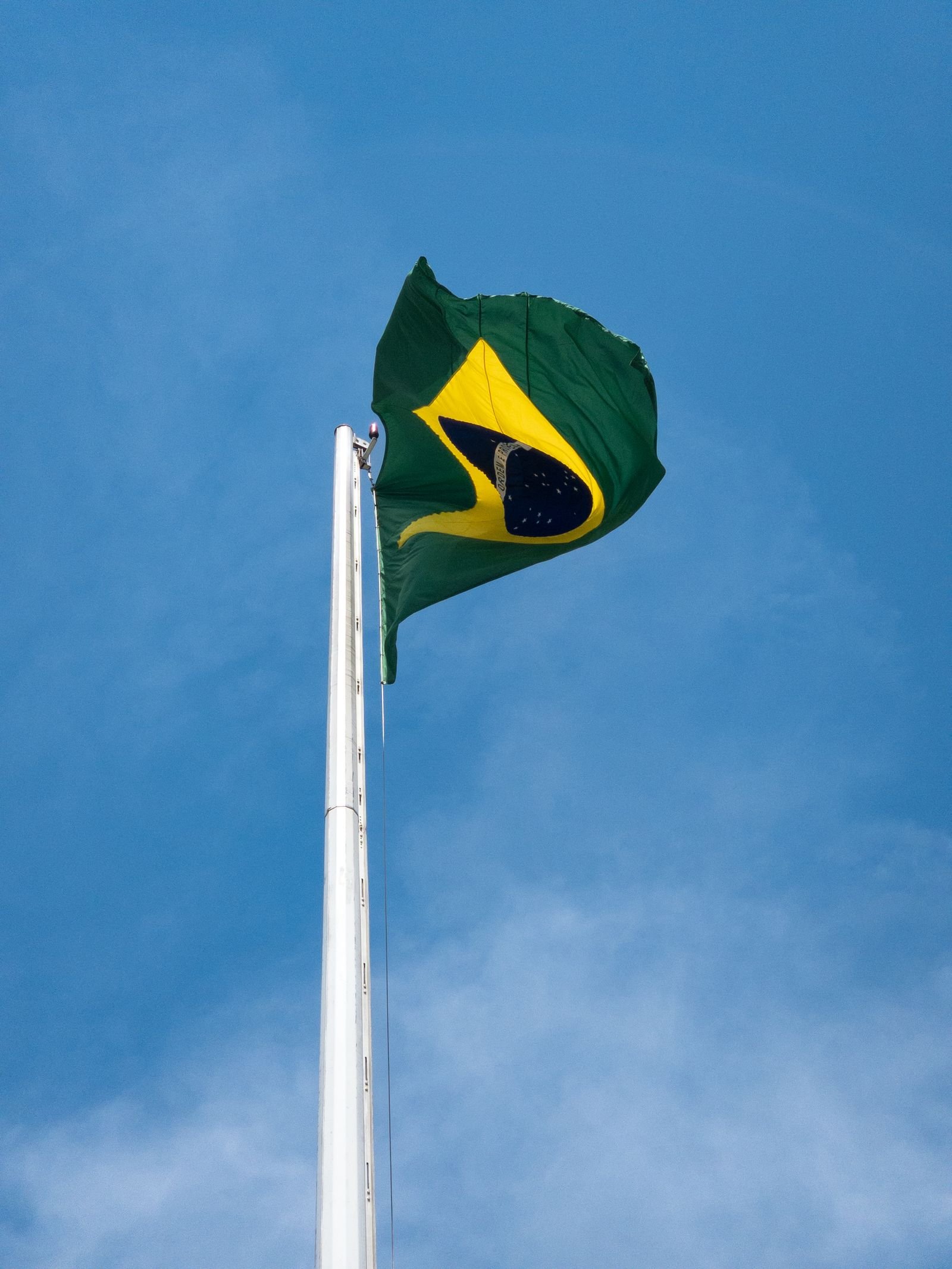 Bandeira do Brasil tremulando contra o céu azul de Brasília