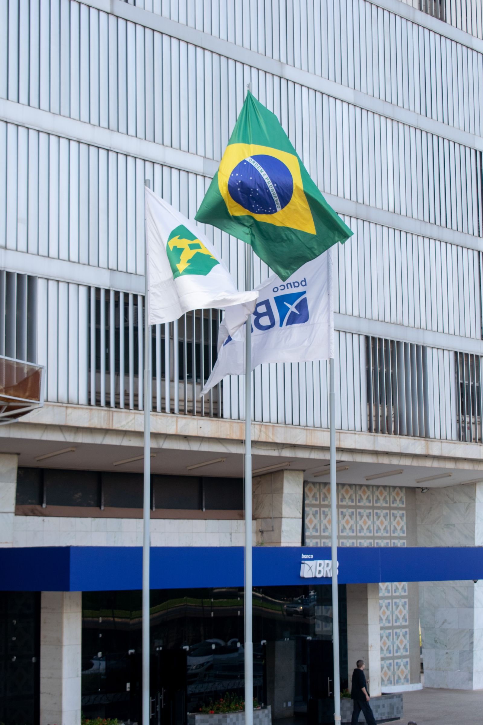 Bandeiras do Brasil e do Distrito Federal hasteadas em frente à sede do banco BRB, em Brasília