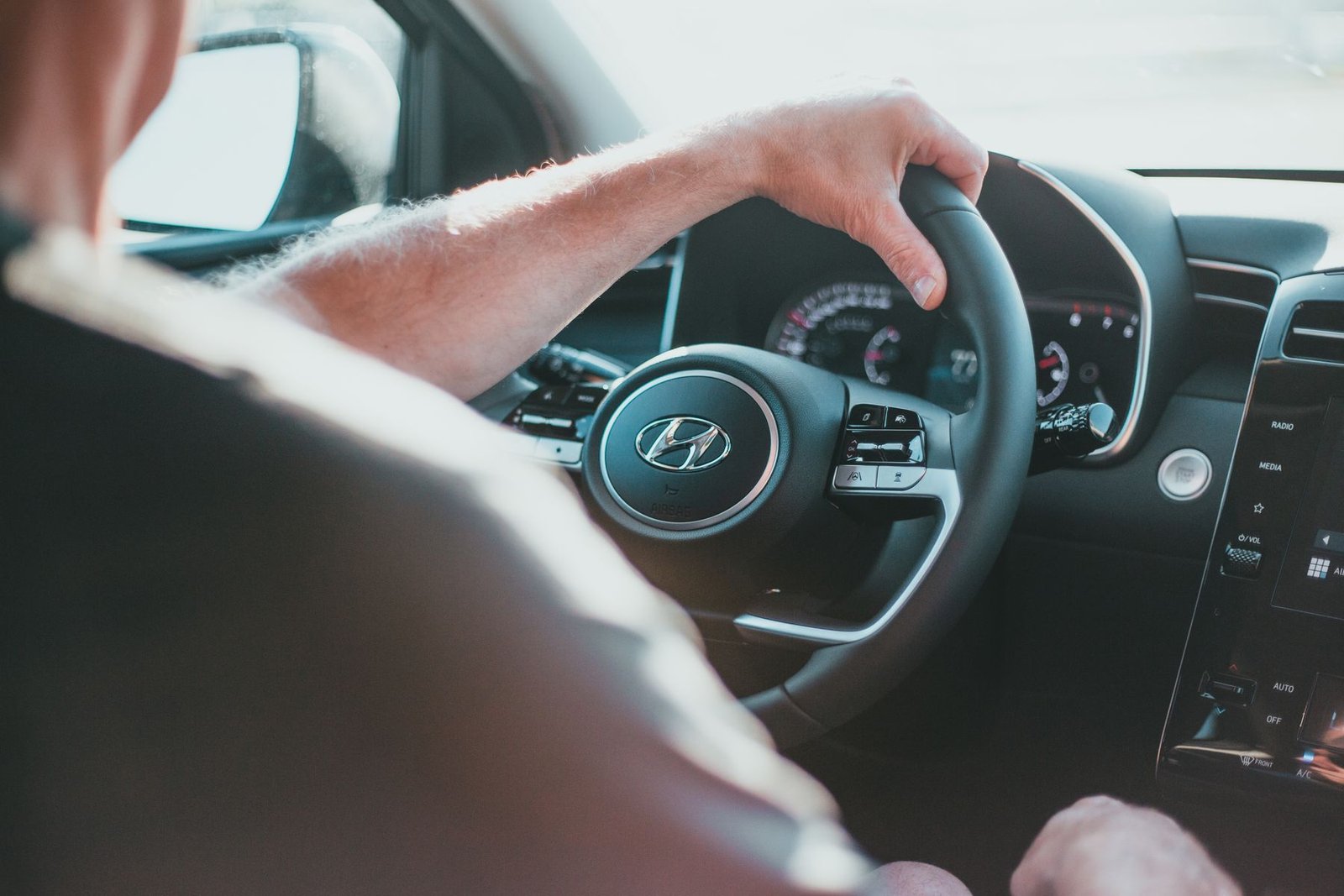 Mãos de motorista no volante de um carro, em foto ilustrativa