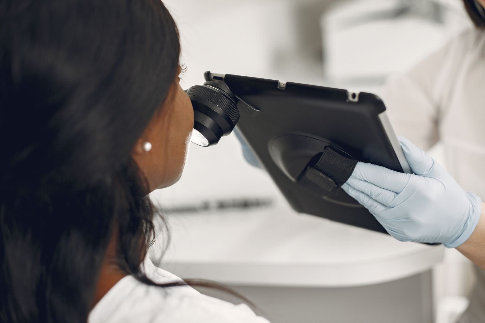 Dermatologista examina a pele de uma paciente com dermatoscópio acoplado a um tablet (foto de arquivo)