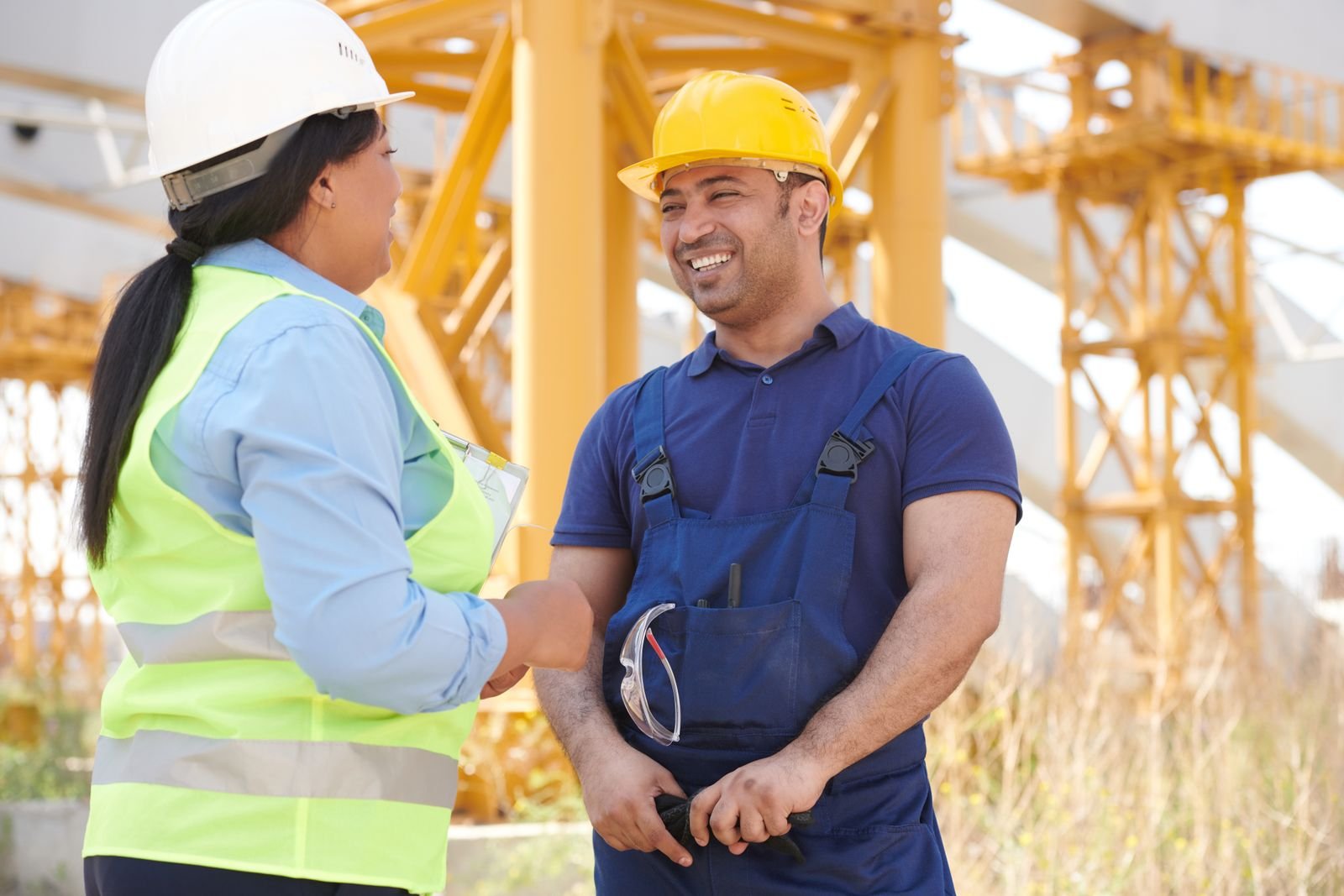 Dois trabalhadores de capacete conversam em uma obra, em foto de arquivo