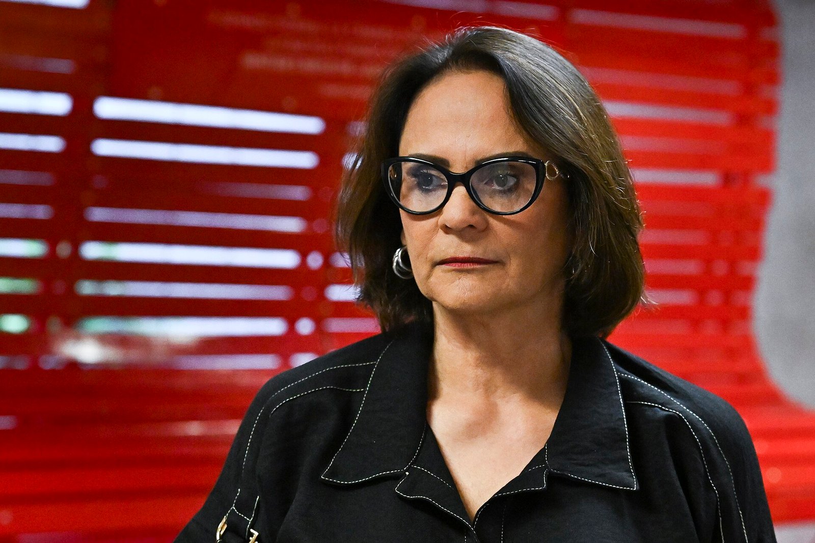 Senadora Damares Alves em retrato com fundo vermelho no Senado Federal