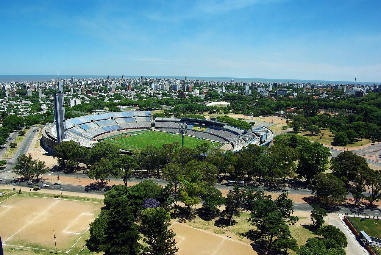 Vista aérea do Estádio Centenário, em Montevidéu, com a cidade e o mar ao fundo