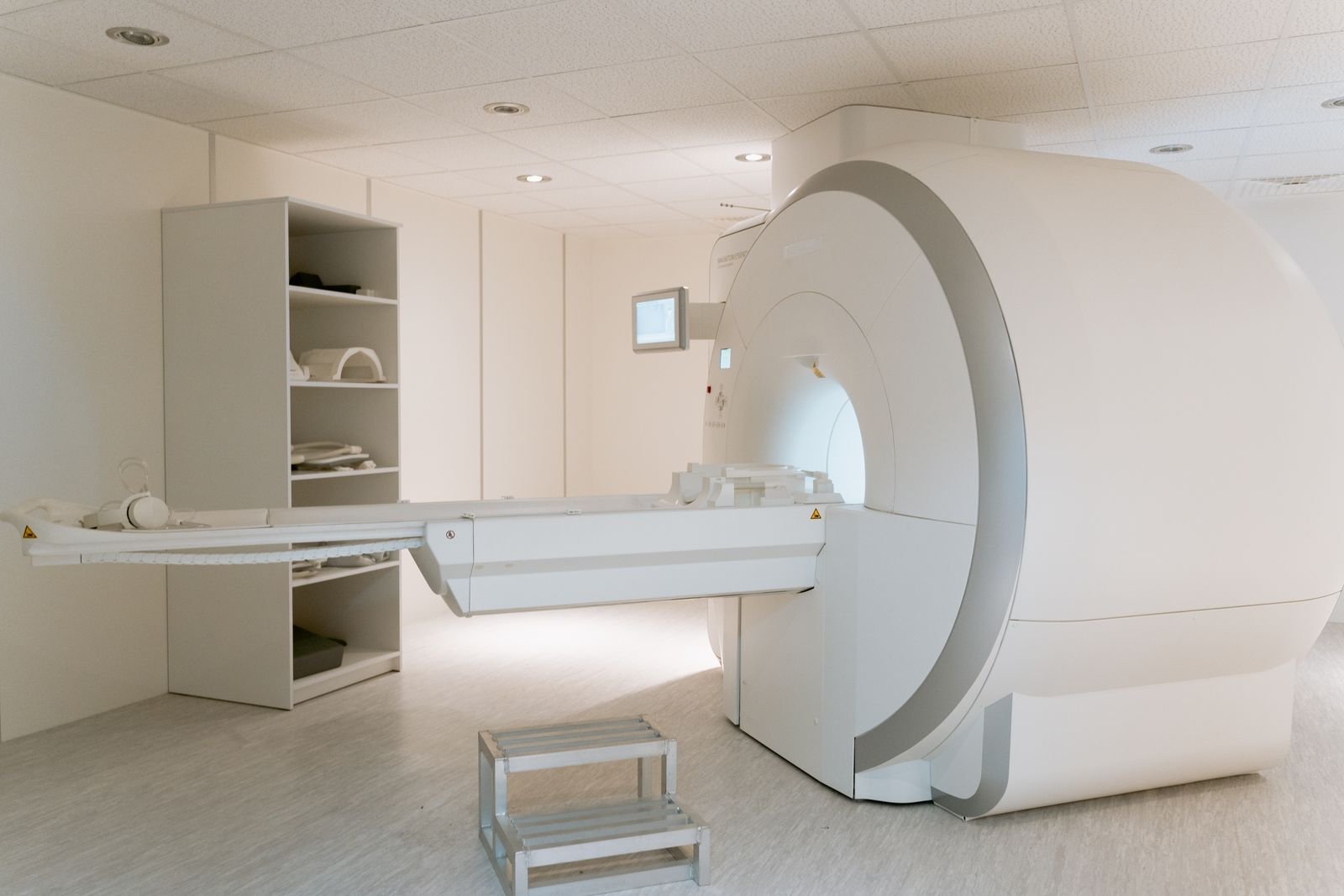 Sala de exame com aparelho de ressonância magnética e maca de paciente