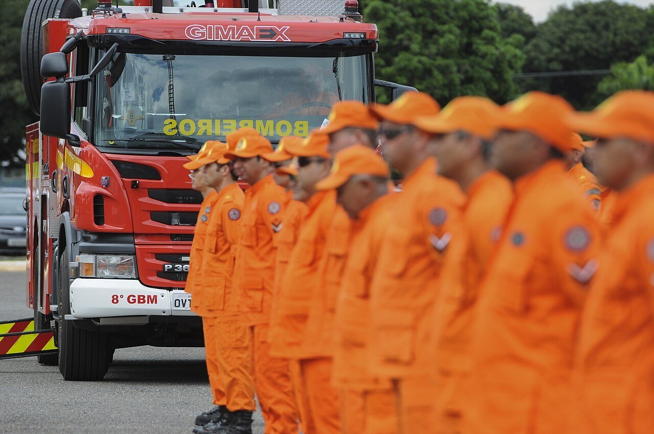 Bombeiros do CBMDF perfilados ao lado de caminhão de combate a incêndio, em foto de arquivo de solenidade de entrega de viaturas
