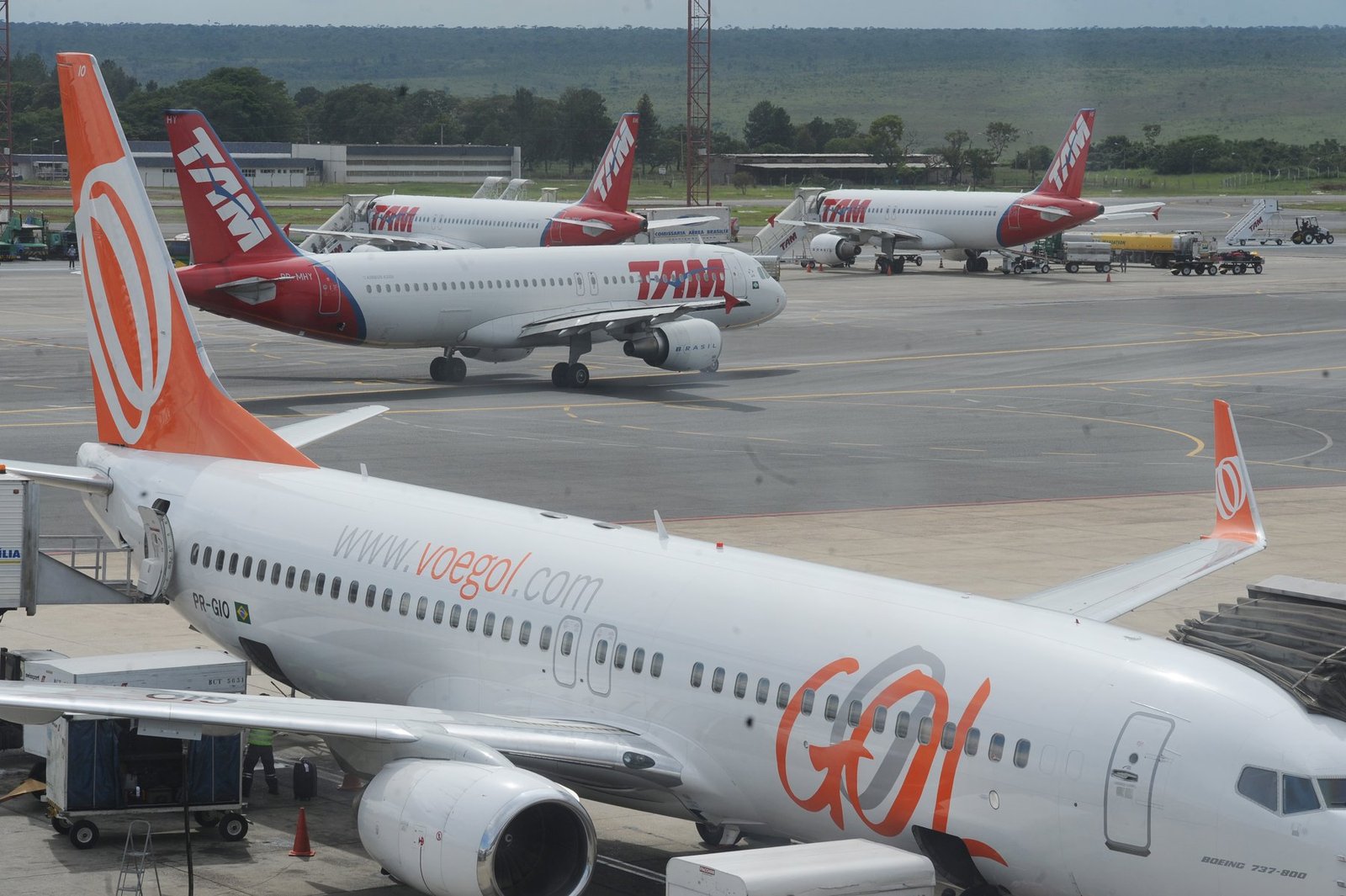 Boeing 737 da Gol estacionado no pátio do aeroporto de Brasília, com aviões da TAM ao fundo