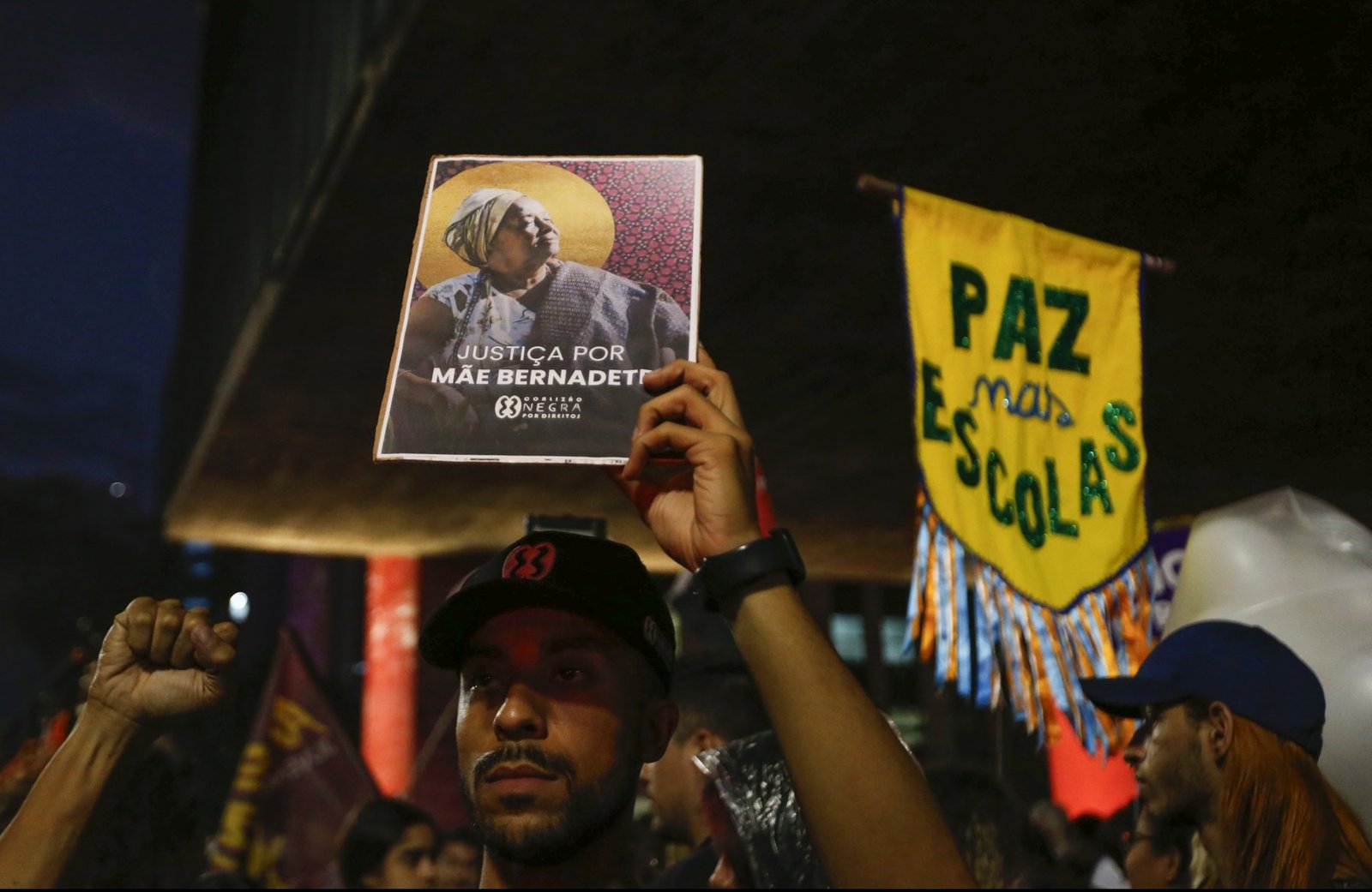 Manifestante ergue cartaz com o rosto de Mãe Bernadete e a frase Justiça por Mãe Bernadete, em ato em São Paulo