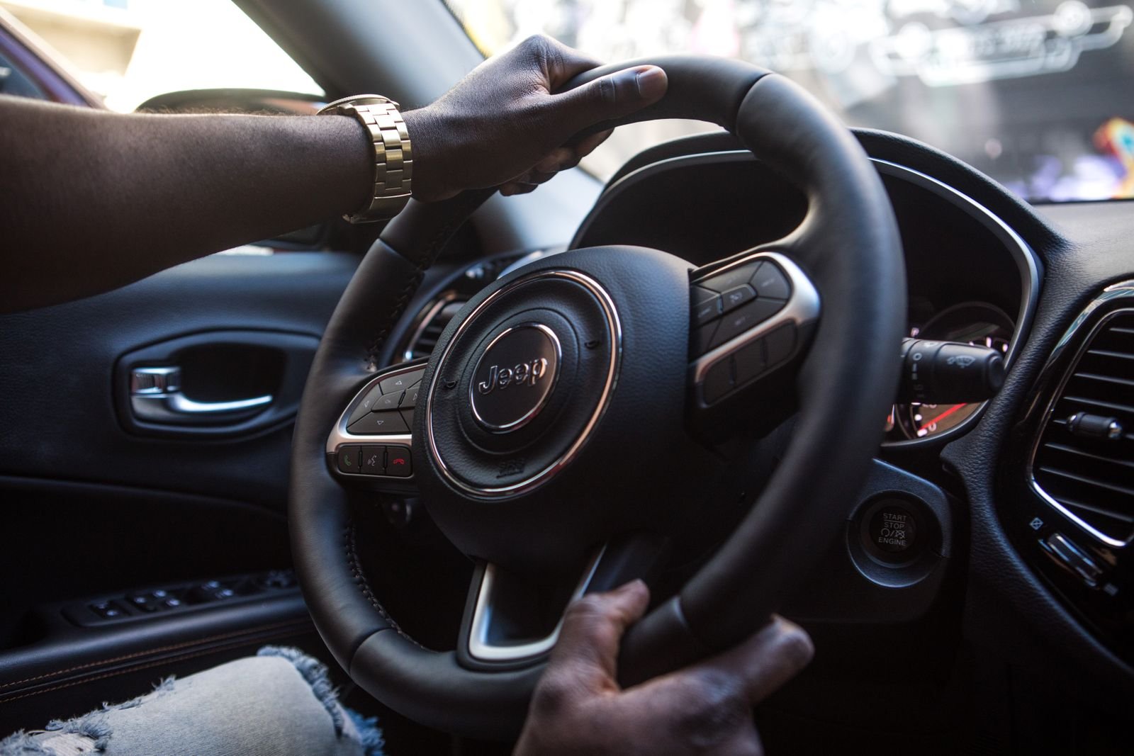 Mãos de motorista no volante de um carro, em aula de direção