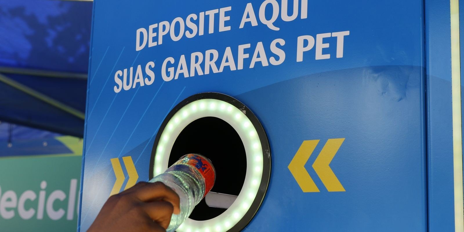 Mão deposita garrafa PET em máquina coletora de recicláveis, em ação no Aterro do Flamengo, no Rio de Janeiro (foto de arquivo)