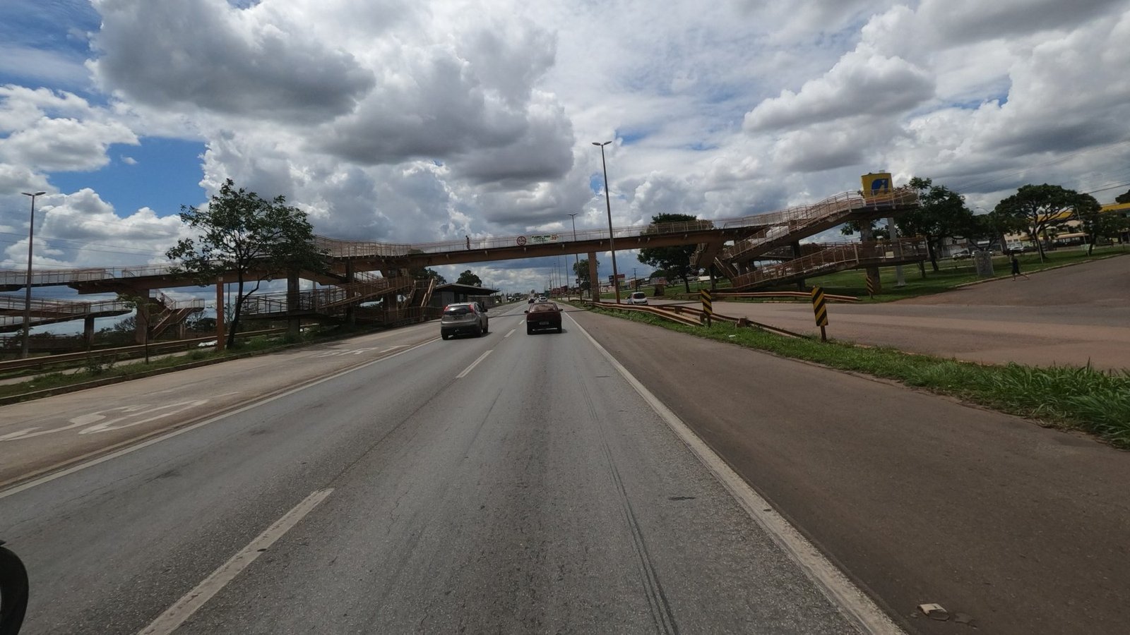 Pista da BR-040 no DF com passarela de pedestres e carros em movimento sob céu nublado, em foto de arquivo