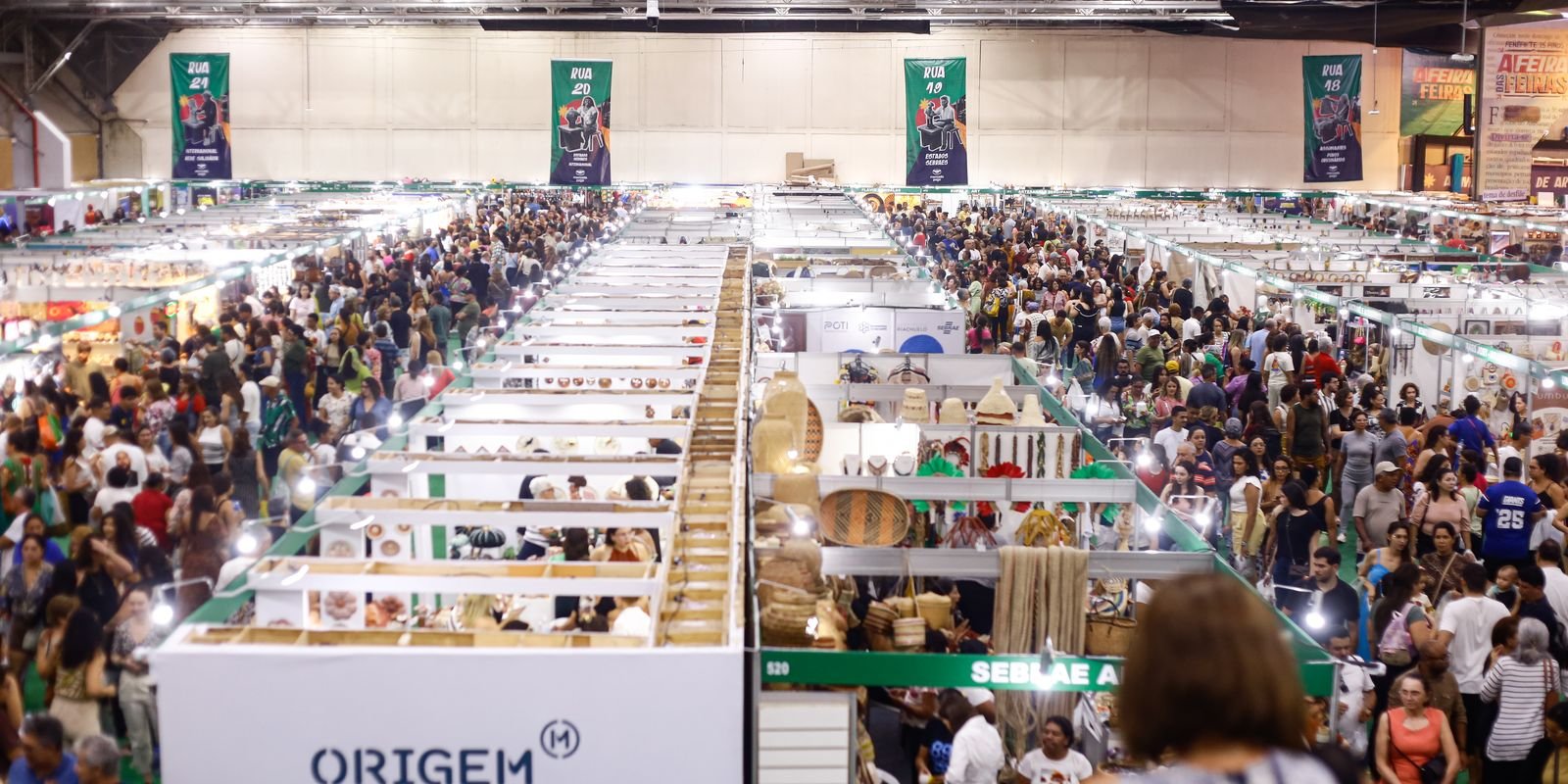 Corredores lotados de uma feira de artesanato e pequenos negócios, com estandes de microempreendedores (foto de arquivo de julho de 2025)