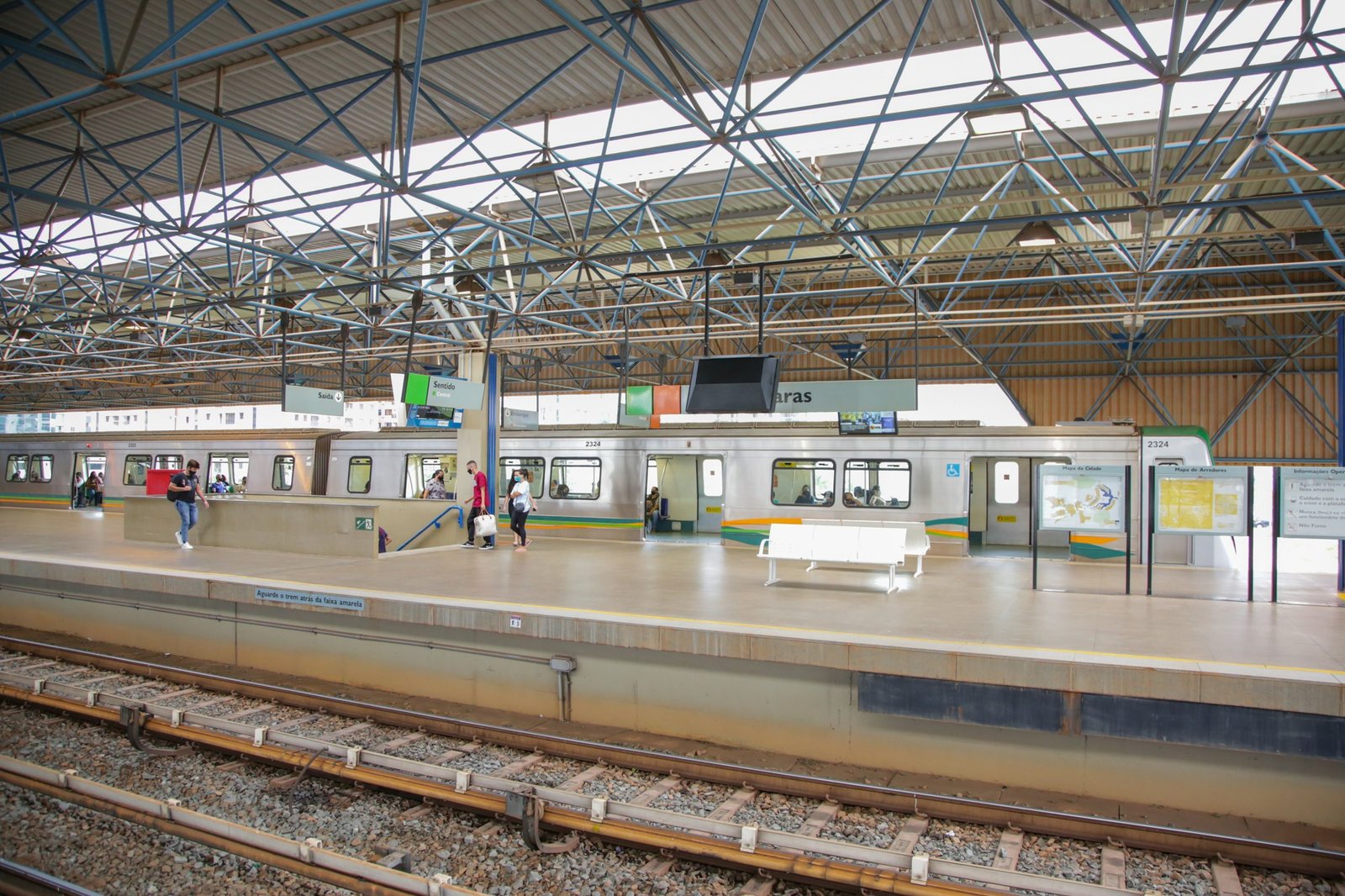 Trem parado na plataforma da estação Águas Claras do Metrô-DF, com passageiros embarcando