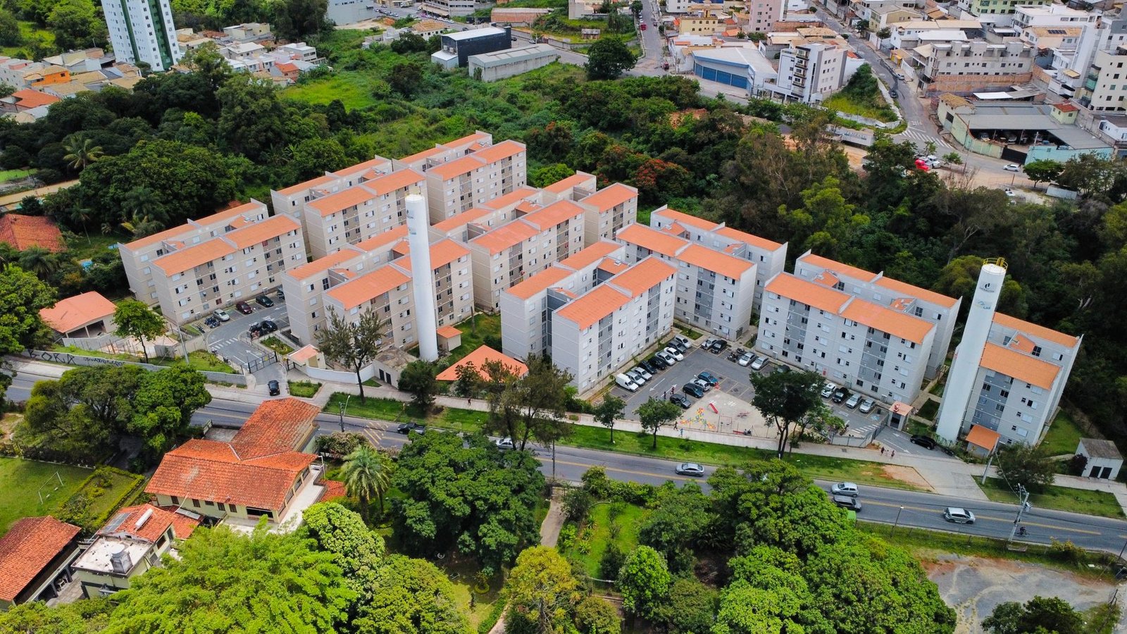 Vista aérea de conjunto de prédios residenciais com telhado alaranjado cercado de vegetação, em Minas Gerais; foto de arquivo