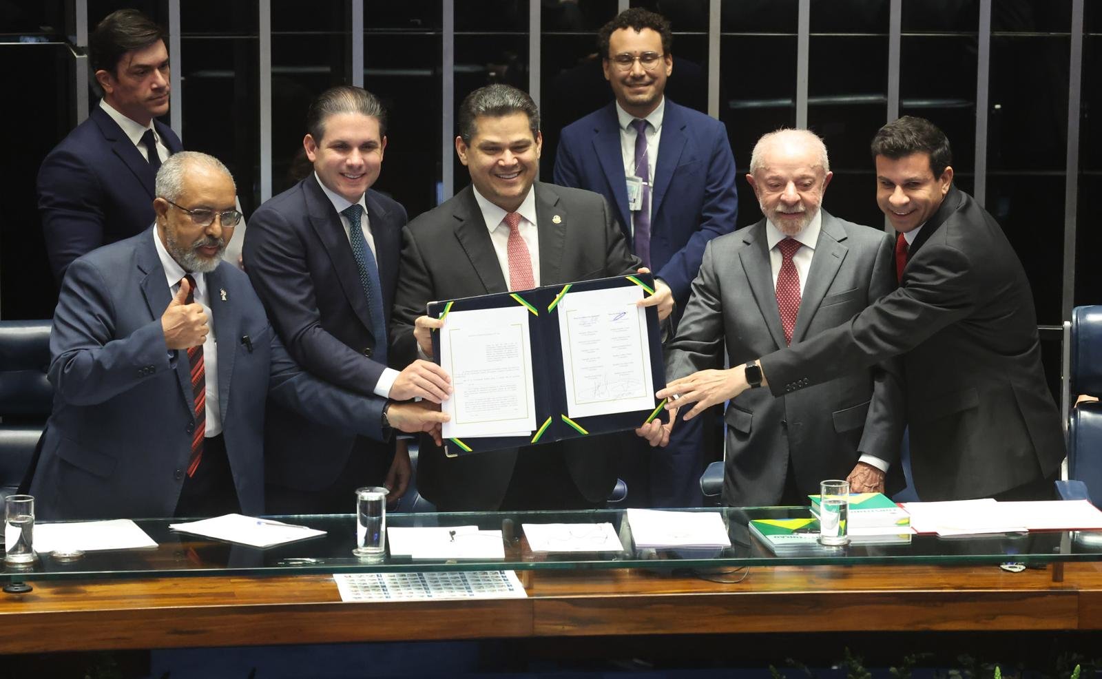 Paulo Paim, Hugo Motta, Davi Alcolumbre, Lula e Carlos Veras exibem o texto da Emenda Constitucional 141 no Congresso