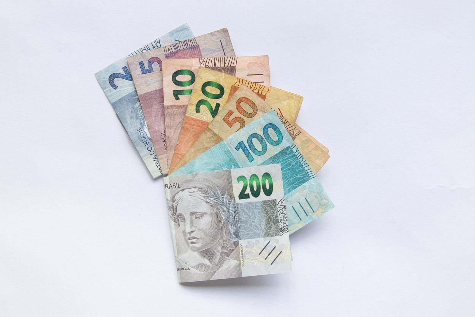 Cédulas de real dispostas em leque sobre fundo branco