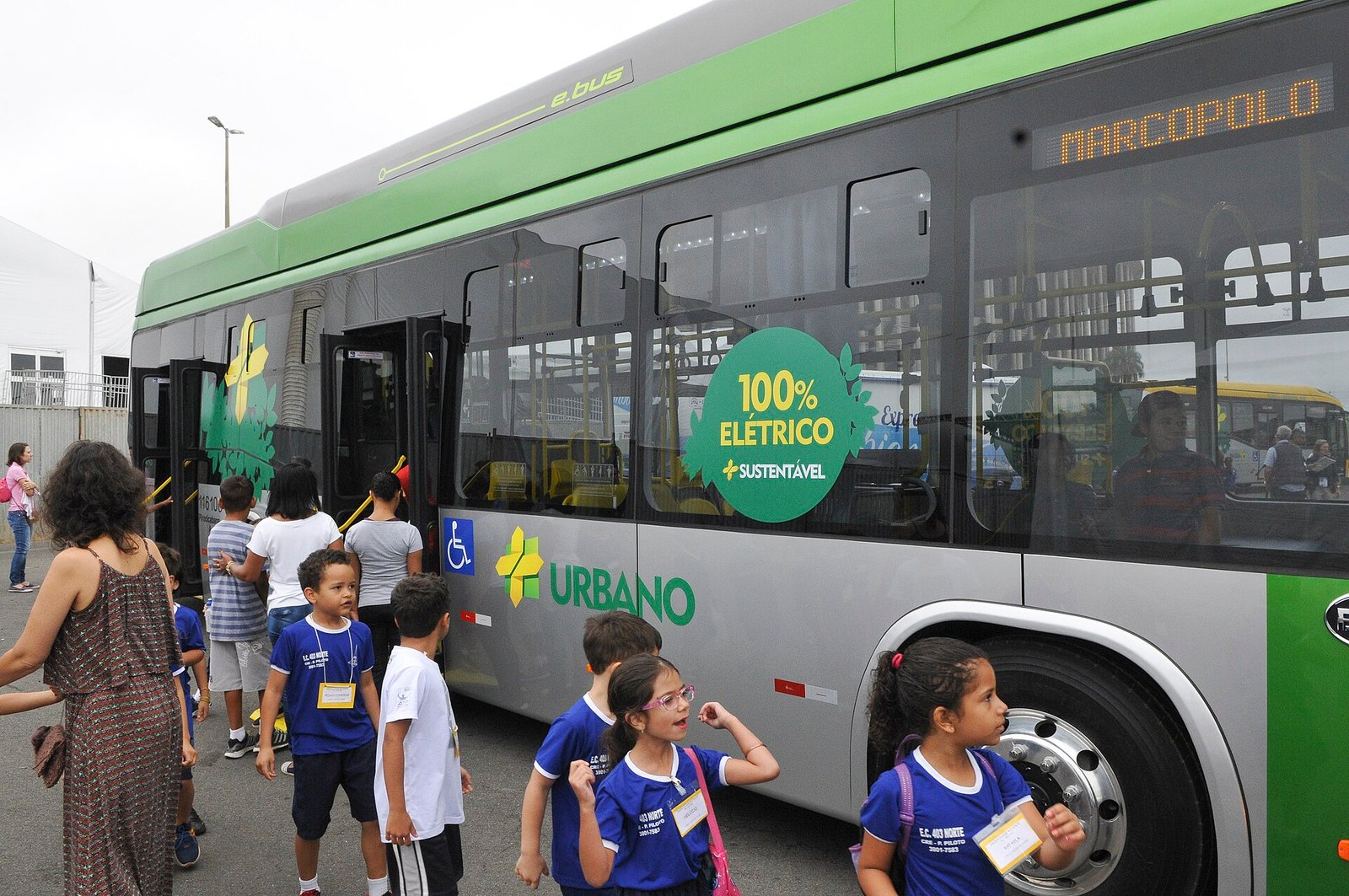 Ônibus 100% elétrico apresentado em Brasília, com crianças embarcando pela porta dianteira