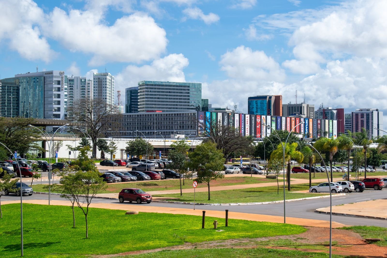 Avenidas, gramados e prédios do centro de Brasília sob céu com nuvens