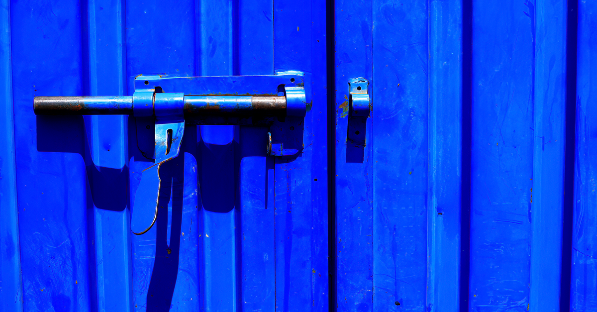 Trinco de metal em porta azul, em foto ilustrativa sobre guarda de armas