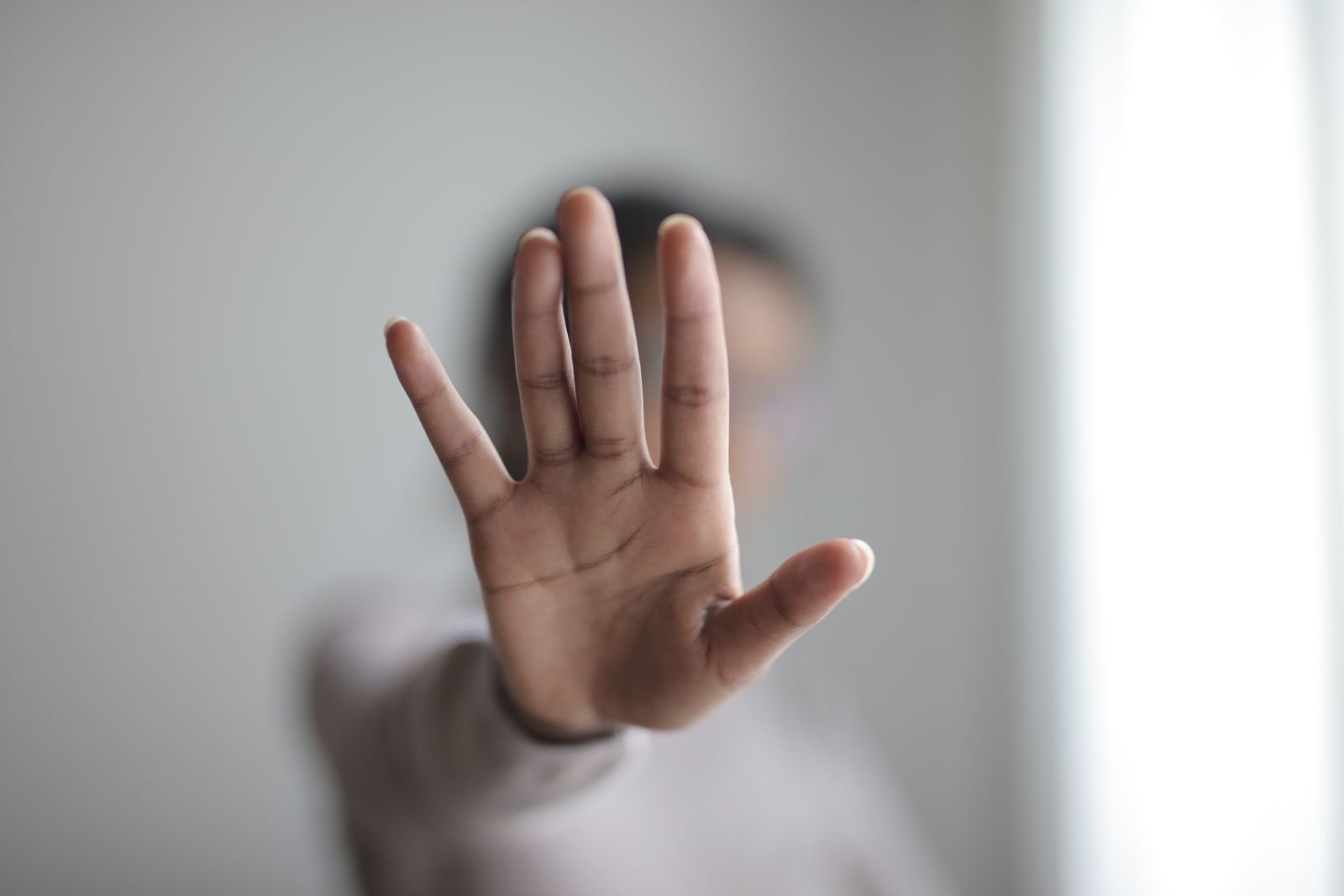 Mão espalmada em gesto de pare em foto ilustrativa sobre violência doméstica