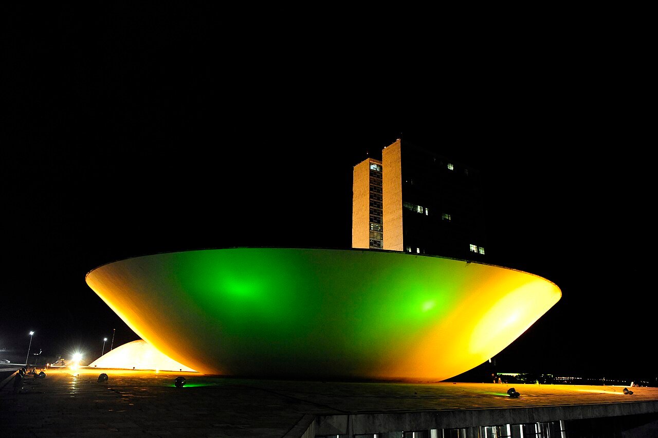 Cúpula da Câmara dos Deputados iluminada à noite, em Brasília