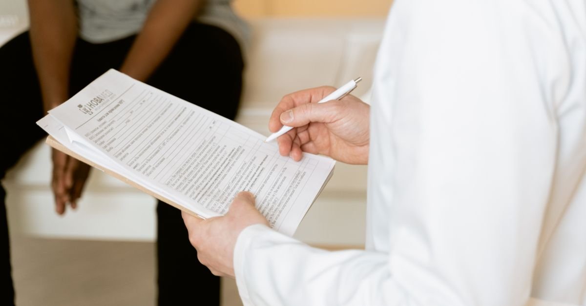 Profissional de saúde preenche formulário durante consulta em clínica