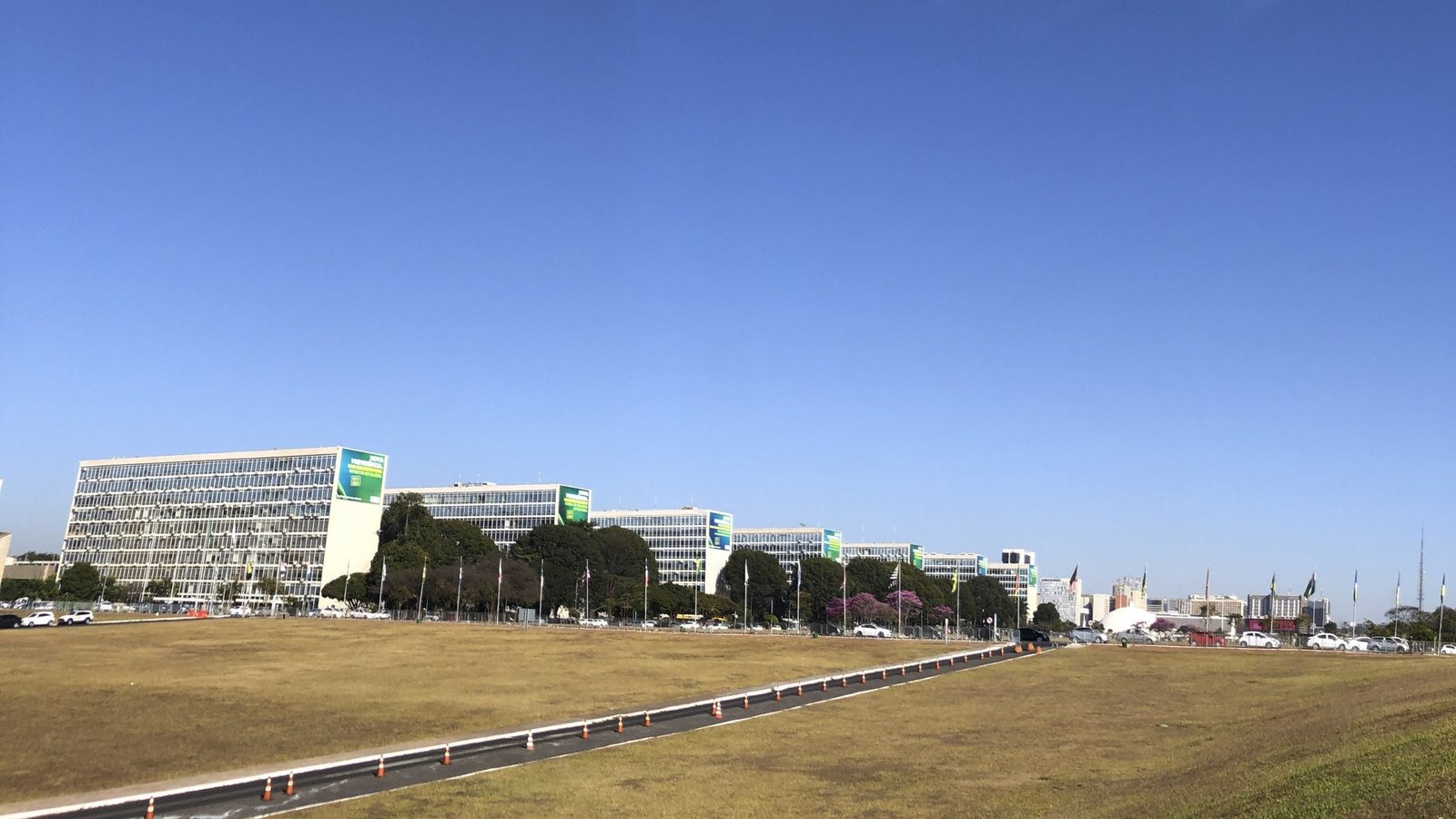 Prédios dos ministérios alinhados na Esplanada dos Ministérios, em Brasília, sob céu azul