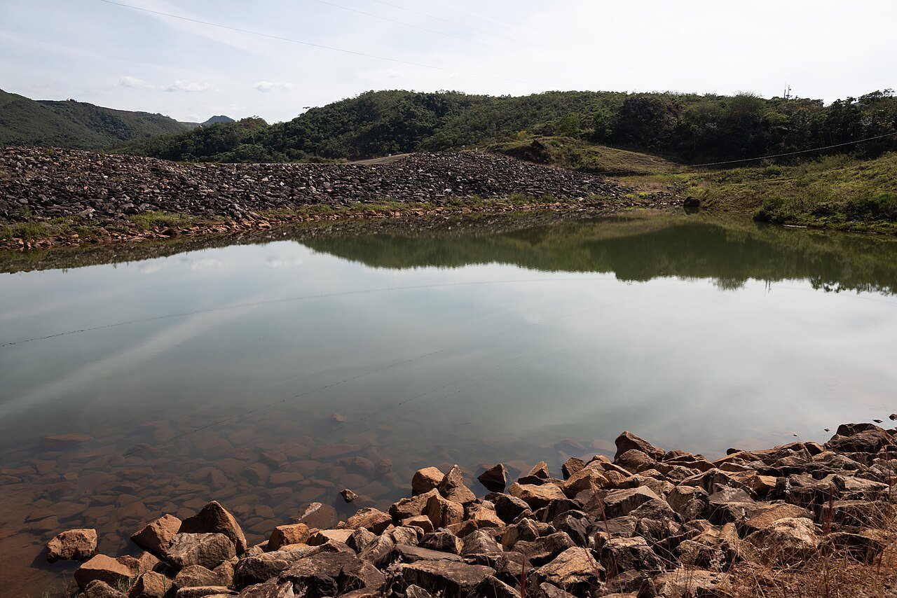 Água do Rio Doce em Bento Rodrigues, Mariana (MG), com margem de pedras e morros ao fundo; foto de arquivo, longe da foz