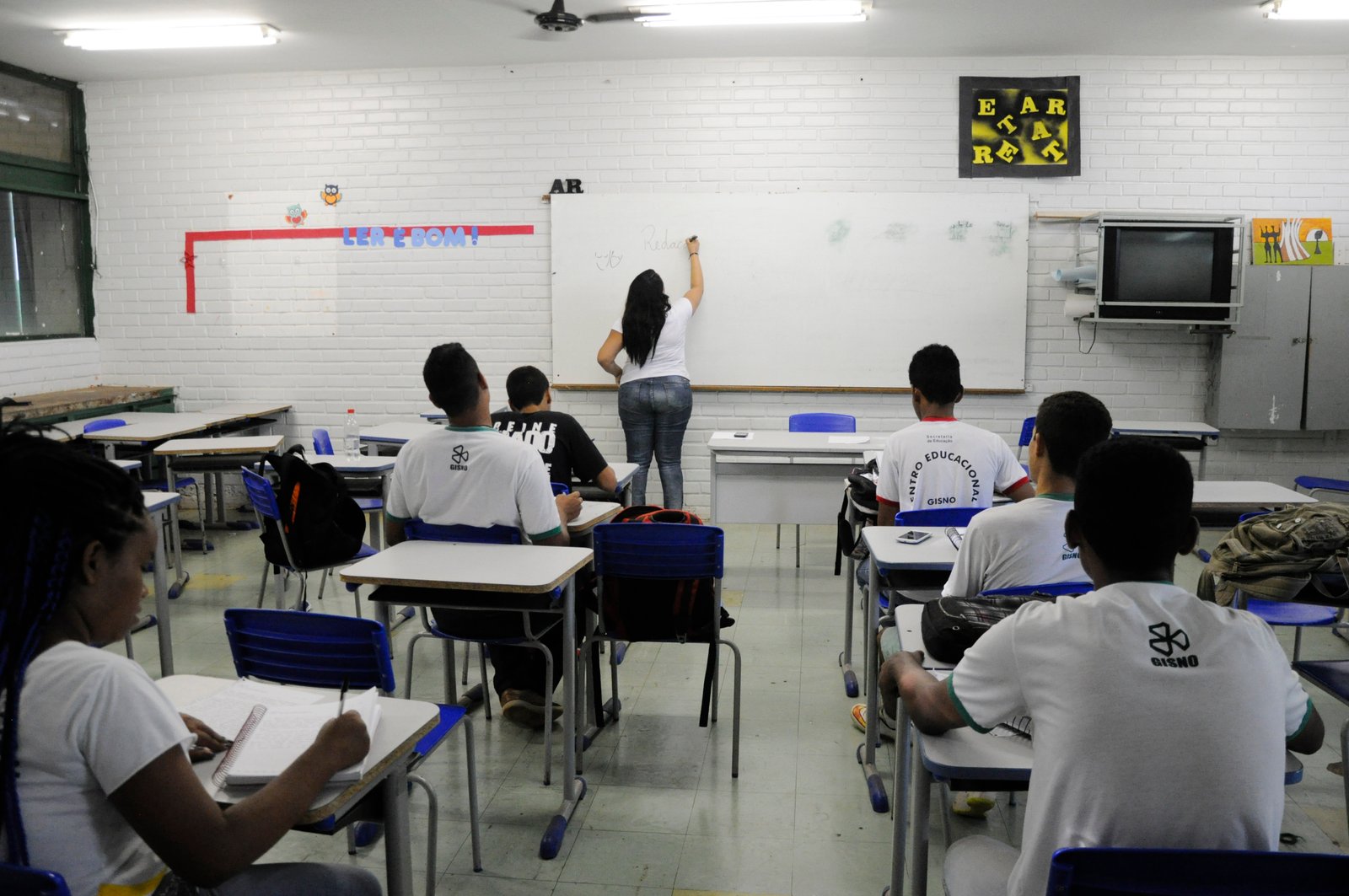 Professora escreve no quadro em sala do Centro Educacional Gisno, na Asa Norte, com alunos de costas; foto de arquivo da Agência Senado, ilustrativa