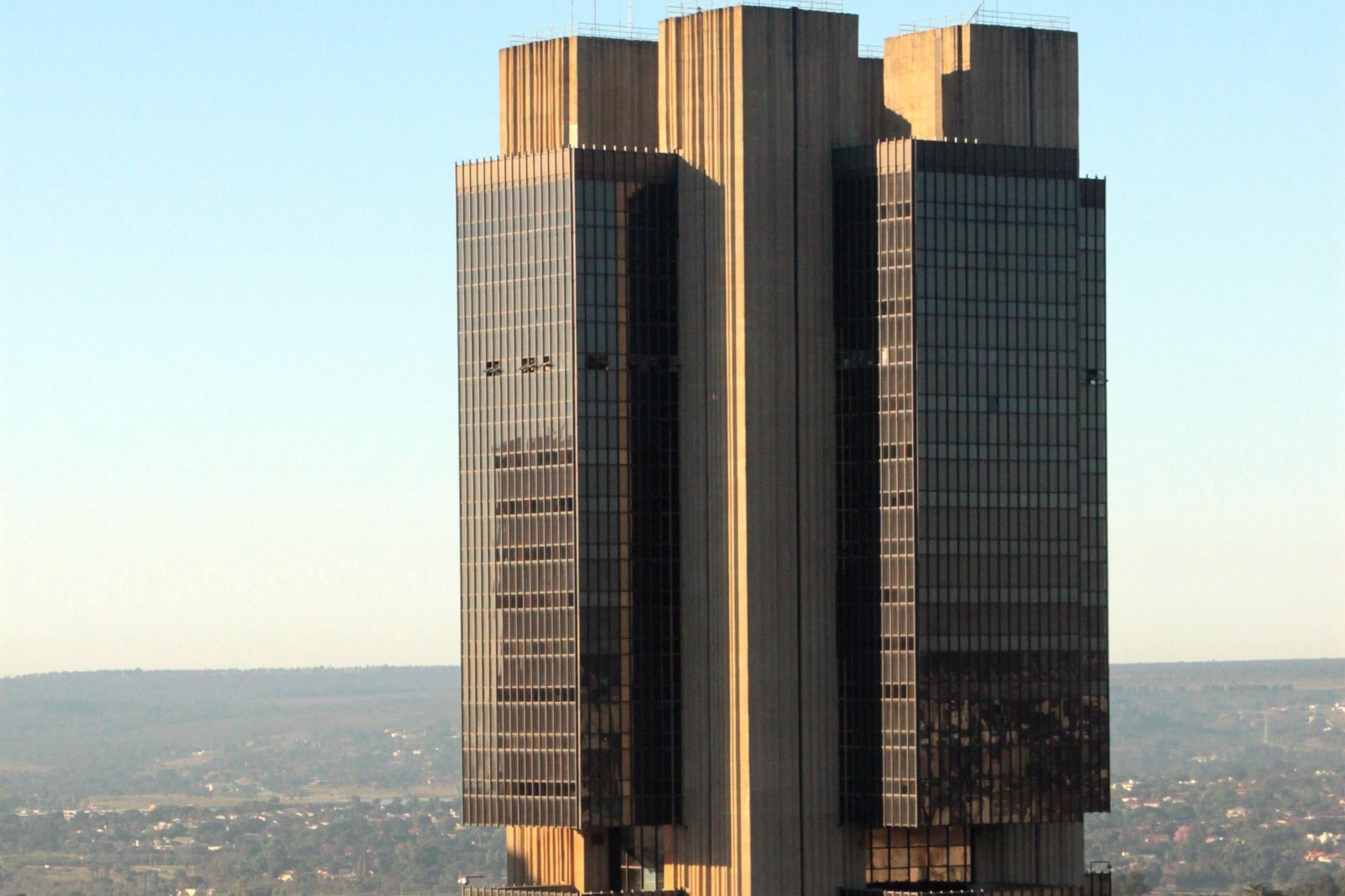 Edifício-sede do Banco Central do Brasil em Brasília visto de cima, com céu azul ao fundo