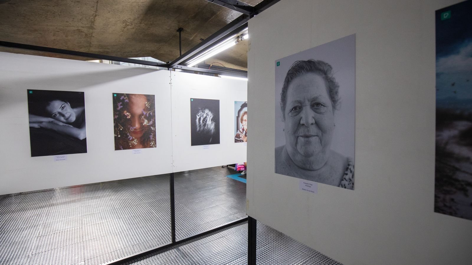 Visitante observa fotografias em preto e branco expostas em galeria de arte