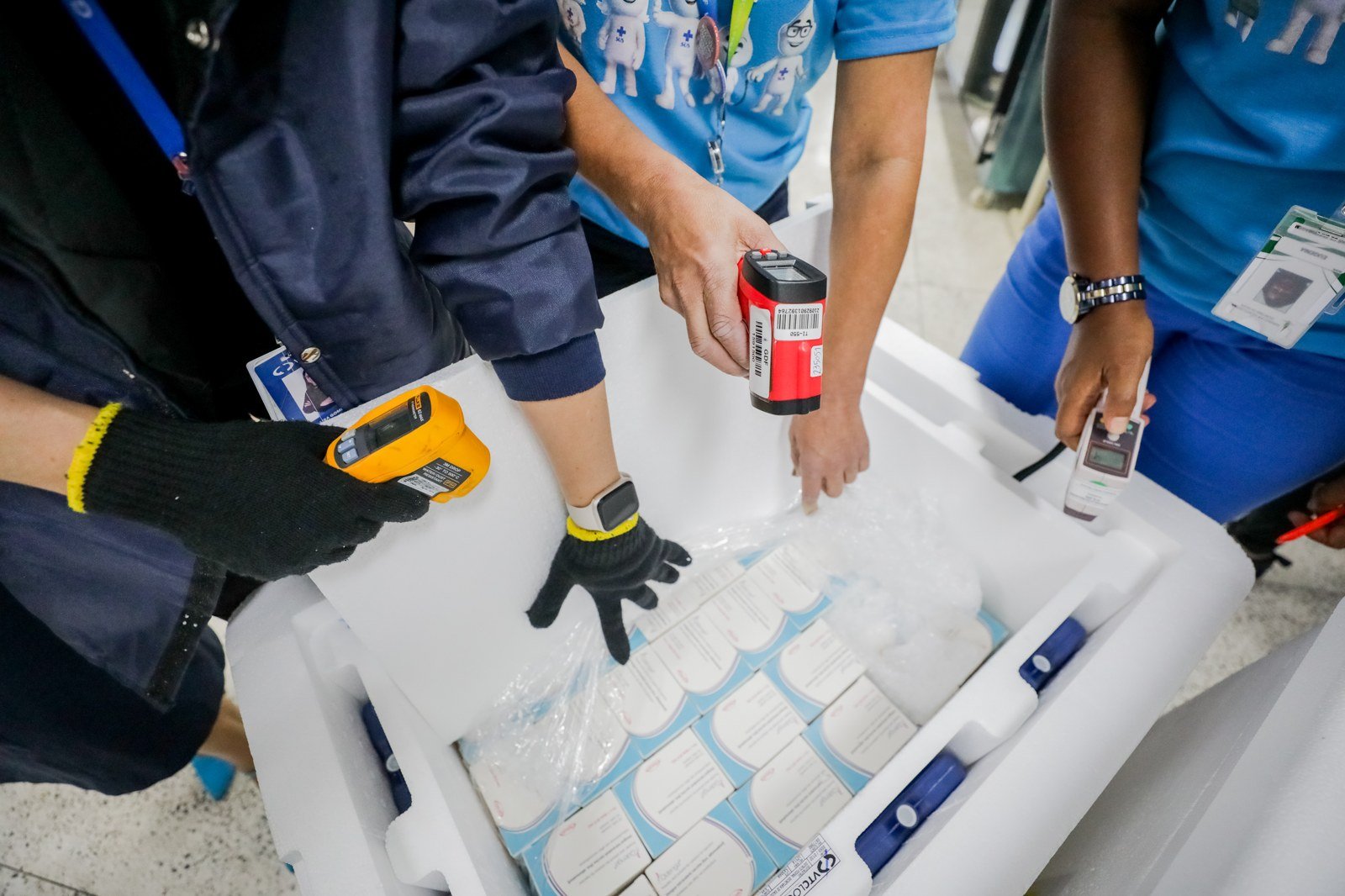 Equipe da Secretaria de Saúde do DF confere com termômetros a temperatura de uma caixa de isopor com doses da vacina contra a dengue, em foto de arquivo de 2024